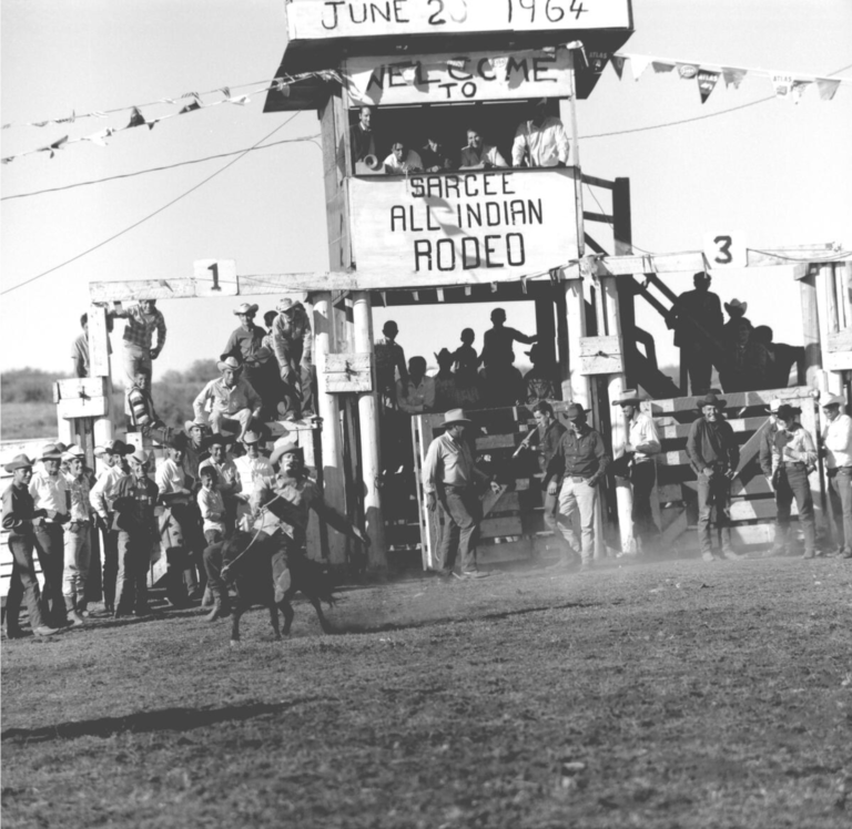 Men and boys watching pony riding at Sarcee All Indian Rodeo 1964